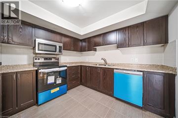 Oakville townhouse for rent - A kitchen with brown cabinets and a blue dishwasher.
