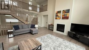 Lake Of Bays (Franklin) apartment for rent - A living room with a grey couch, a wooden coffee table, and a staircase.