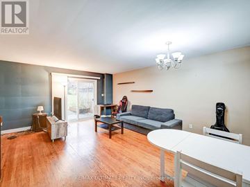 Niagara Falls (Stamford) townhouse for rent - A living room with a grey couch and a white table.