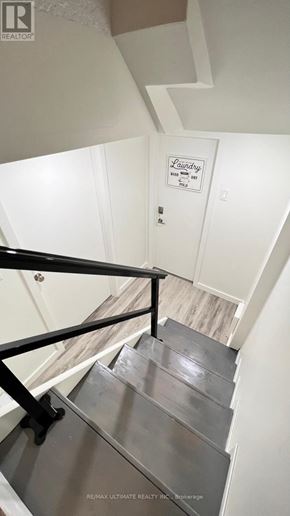 Toronto (O'connor-Parkview) apartment for rent - A staircase with a metal railing and a sign that says Laundry.