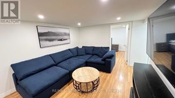 Toronto (O'connor-Parkview) apartment for rent - A living room with a blue sectional sofa and a wooden coffee table.