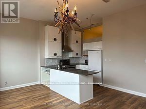Toronto (Niagara) condo for rent - A kitchen with a white island and a chandelier.