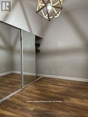 Toronto (Niagara) condo for rent - A room with wooden floors and a glass partition wall.