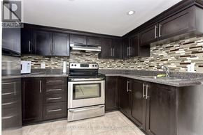 Toronto (Dovercourt-Wallace Emerson-Junction) apartment for rent - A kitchen with dark wood cabinets and a stone backsplash.
