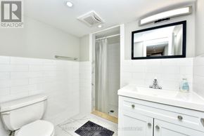 Toronto (Dovercourt-Wallace Emerson-Junction) apartment for rent - A white bathroom with a toilet, sink, and mirror.