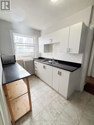 Toronto (Yonge-Eglinton) multi-family for rent - A kitchen with white cabinets and a black countertop.
