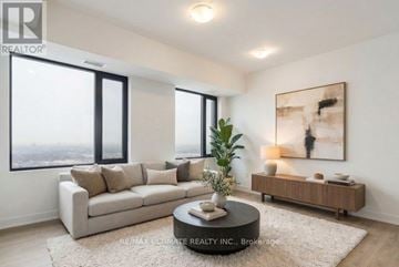 Vaughan (Concord) condo for rent - A living room with a large window, a sofa, a coffee table, and a painting on the wall.