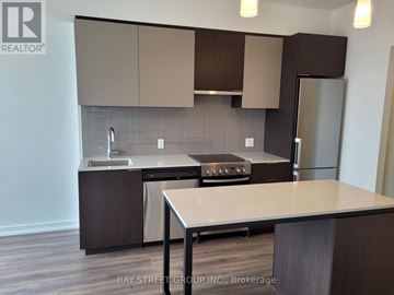 Toronto (Kensington-Chinatown) condo for rent - A kitchen with a table and a refrigerator.
