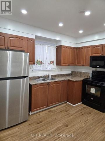 Toronto (Kennedy Park) apartment for rent - A kitchen with wooden cabinets and a stainless steel refrigerator.