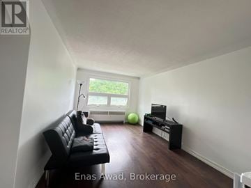 Ottawa triplex for rent - A living room with a black leather sofa and a green exercise ball.