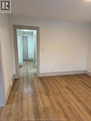 Windsor apartment for rent - A room with wooden flooring and a doorway leading to another room.