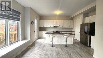 Georgina (Sutton & Jackson's Point) apartment for rent - A modern kitchen with white cabinets and a bar area.
