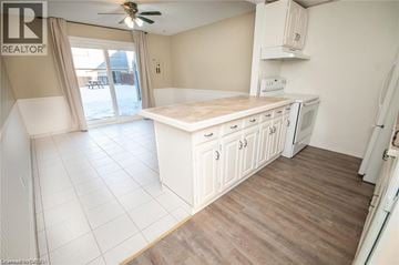 Niagara Falls townhouse for rent - A kitchen with white cabinets and a wooden floor.
