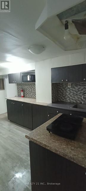 Toronto (Clairlea-Birchmount) apartment for rent - A kitchen with a counter top and a microwave.