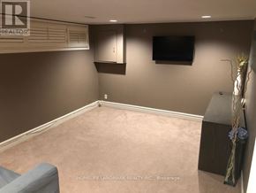 Toronto (Bayview Village) apartment for rent - A living room with a grey couch and a flat screen TV mounted on the wall.