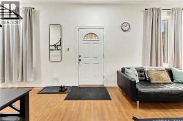 Brantford apartment for rent - A living room with a black couch and a white door.