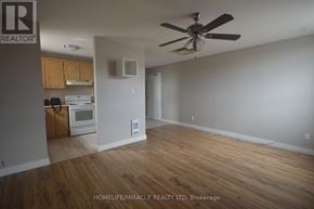 Bradford West Gwillimbury (Bradford) apartment for rent - A room with a ceiling fan and a kitchen area in the background.