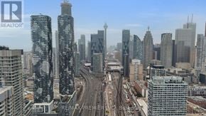 Toronto (Waterfront Communities) condo for rent - A cityscape with tall buildings and a highway in the foreground.