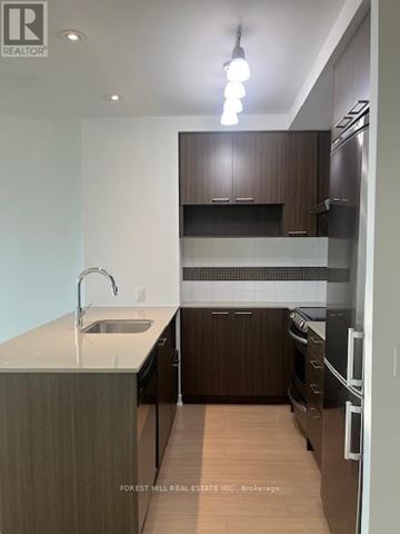 Toronto (Forest Hill South) house for rent - A modern kitchen with dark wood cabinets and stainless steel appliances.
