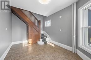 Orillia multi-family for rent - A room with a wooden staircase and tiled floor.