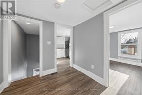 Orillia multi-family for rent - A spacious, empty room with wood flooring and white walls.
