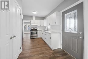 Orillia duplex for rent - A kitchen with white cabinets and a grey door.