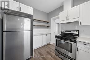 Orillia duplex for rent - A kitchen with a stainless steel refrigerator and a stove top oven.