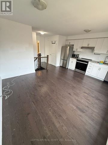 Toronto (Rustic) condo for rent - A kitchen with white cabinets and a wooden floor.