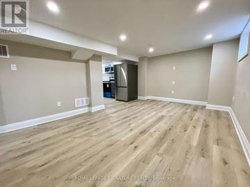 Hamilton (Inch Park) apartment for rent - A spacious room with wooden flooring and a kitchenette in the corner.