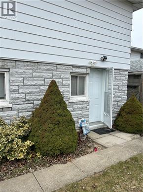 Hamilton apartment for rent - A house with a white door and a small tree in front of it.