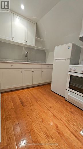 Toronto (Dovercourt-Wallace Emerson-Junction) apartment for rent - A kitchen with white cabinets and a wooden floor.