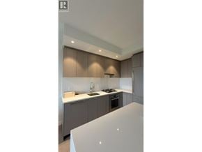 Vancouver apartment for rent - A modern kitchen with a white countertop and grey cabinets.