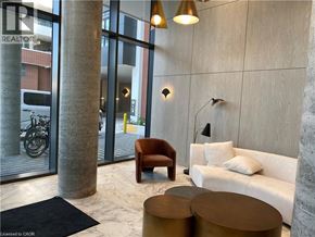 Kitchener condo for rent - A modern living room with a sofa, armchair, and coffee table.