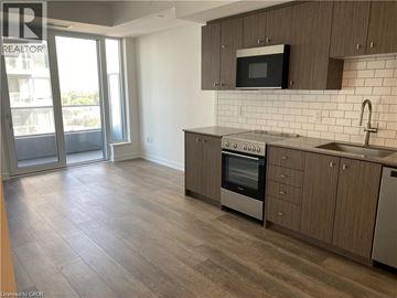 Kitchener condo for rent - A kitchen with a stove top oven and microwave.