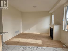 Cobourg apartment for rent - A spacious room with wooden flooring and a fireplace.