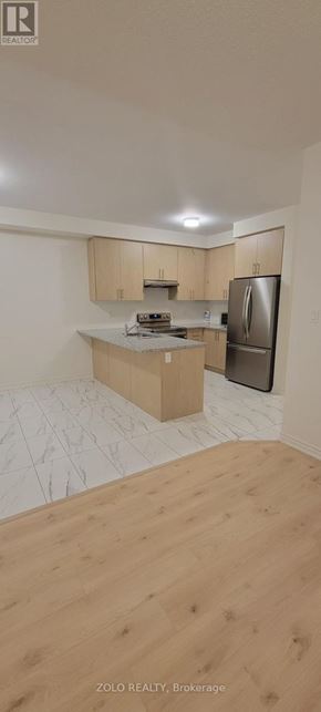Cobourg apartment for rent - A kitchen with wooden cabinets and a refrigerator.