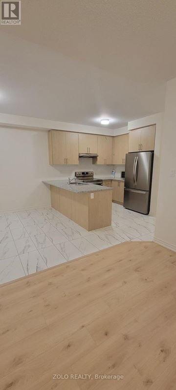 Cobourg apartment for rent - A kitchen with wooden cabinets and a refrigerator.