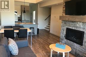 Blue Mountains condo for rent - A living room with a fireplace and a dining table.