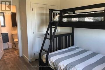 Blue Mountains condo for rent - A bedroom with a bunk bed and a striped bedspread.