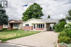 Kitchener apartment for rent - A house with a brick driveway and a green lawn.