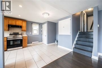 Kitchener apartment for rent - A kitchen with wooden cabinets and a black oven.