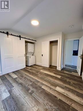 Kawartha Lakes (Lindsay) apartment for rent - A room with wooden flooring and white walls.