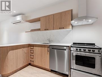 Toronto (Yonge-Eglinton) multi-family for rent - A kitchen with wooden cabinets and stainless steel appliances.