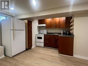 Newmarket (Bristol-London) apartment for rent - A kitchen with a white fridge and wooden cabinets.