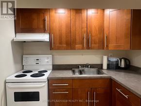 Newmarket (Bristol-London) apartment for rent - A kitchen with wooden cabinets and a white stove top oven.