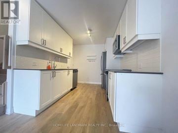 Vaughan (Concord) townhouse for rent - A kitchen with white cabinets and a wooden floor.