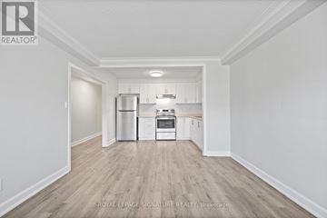Toronto (Mimico) multi-family for rent - A kitchen with white cabinets and a stainless steel refrigerator.