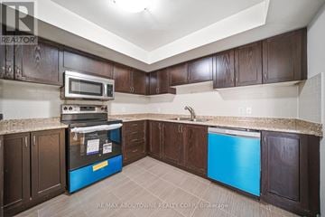 Oakville (Wm Westmount) townhouse for rent - A kitchen with brown cabinets and a blue fridge.