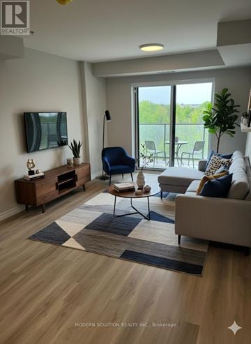 Guelph (Grange Road) condo for rent - A living room with a blue chair and a white couch.