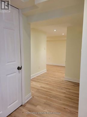 Markham (Unionville) apartment for rent - A white door is on the left of a hallway with wooden floors.